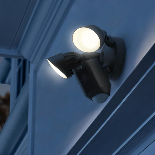 Ring Floodlight Cam Wired Plus met ingeschakelde schijnwerpers in het donker