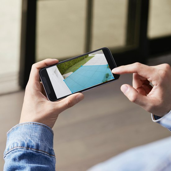 Livebeeld van een buitenruimte via de Ring-app op een smartphone